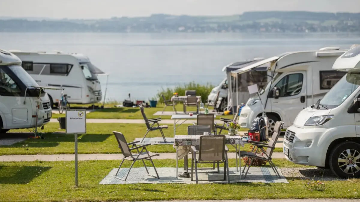 Ausgebuchter Campingplatz am Bodensee mit Wohnmobilen und Reservierungsschild