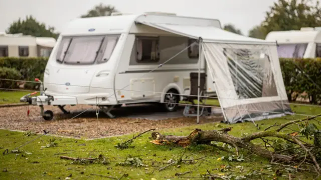 Sturmschäden am Dauercampingplatz: verschobene Markise, Abspannseile und Äste neben dem Wohnwagen