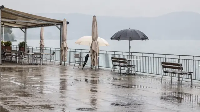 Regnerische Uferpromenade am Bodensee mit Schirmen und nasser Fläche als Thema für Aktivitäten bei Regen